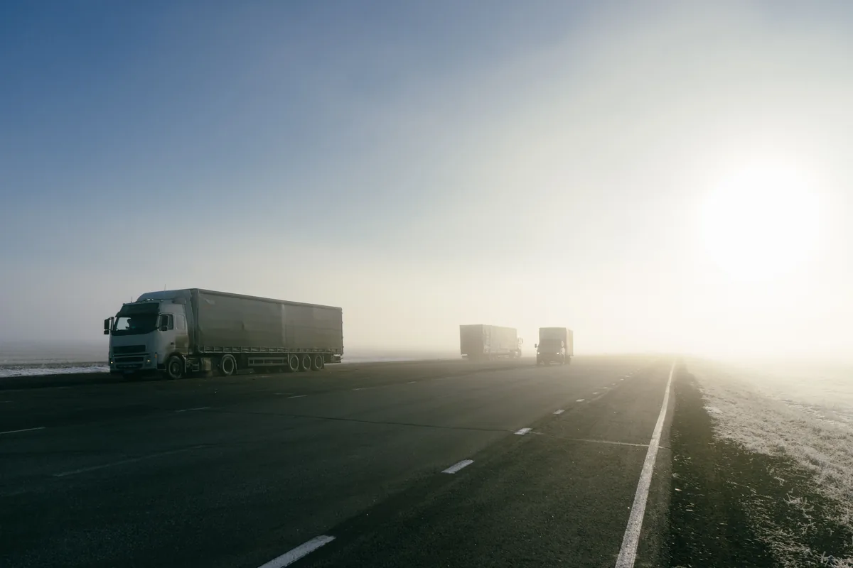 Convoi de poids lourds sur un axe routier au petit matin