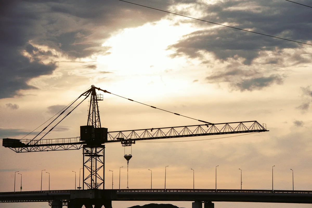 Grue à tour sur un chantier d’ouvrage d’art au crépuscule